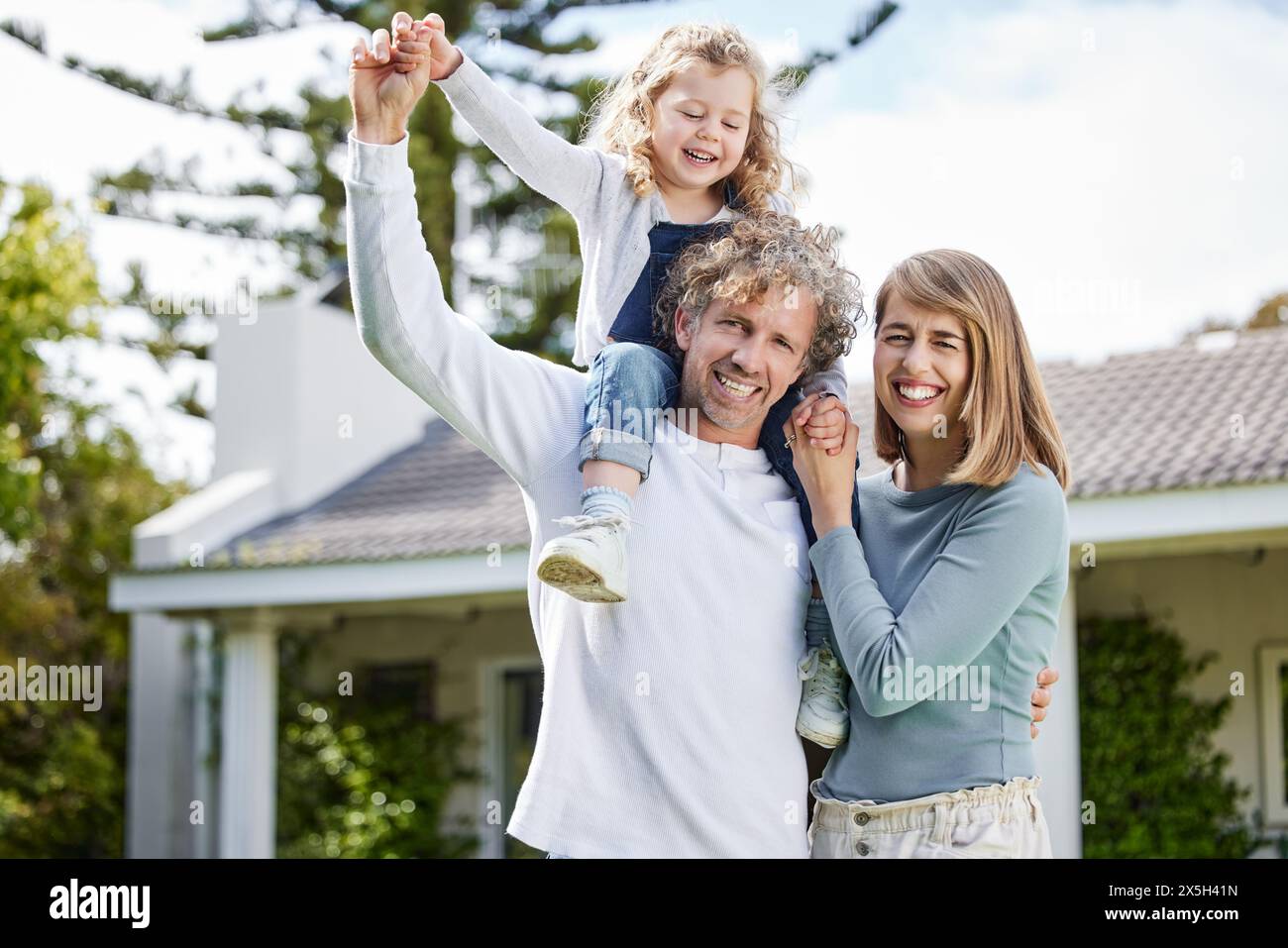 Mutter, Vater und Kind im Hinterhof-Porträt mit Lächeln, Verbundenheit und verspieltem Spaß, Frieden und Ruhe am Sommerwochenende. Glückliche Familie, Eltern und Mädchen zusammen Stockfoto