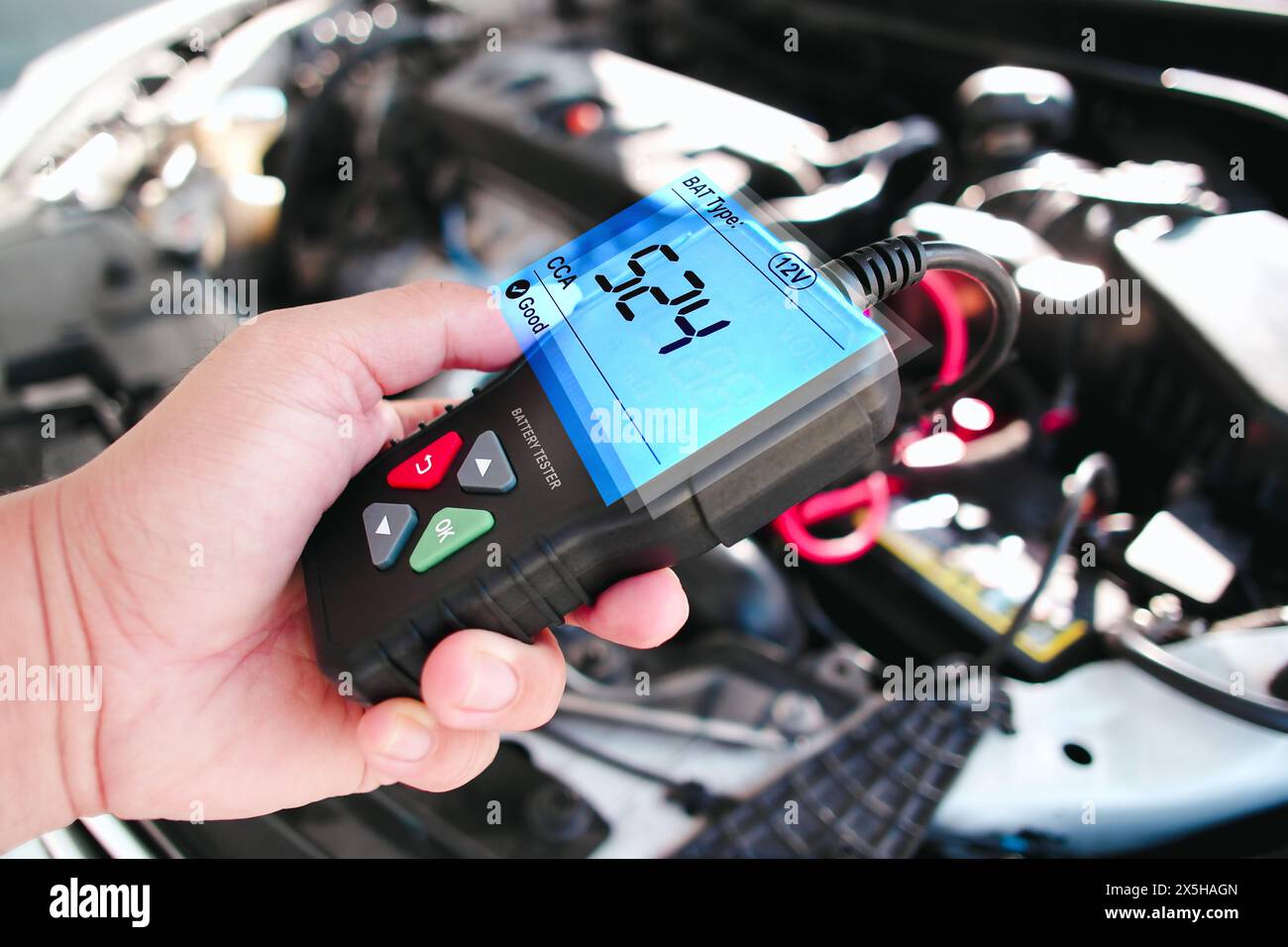 Kfz-Techniker überprüft CCA Kaltstartverstärker der Kfz-Batterie mit Batterieprüfgerät in der Autoreparaturgarage , Kfz-Wartungsservice-Konzept Stockfoto