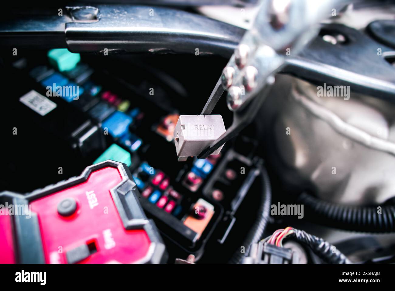 Elektromagnetischer Relais-Schalter für das Auto mit einer Zange zum Entfernen von Relais für die Prüfung mit einem Relaisprüfer entfernt , Konzepte zu elektronischen Fahrzeugbauteilen Stockfoto