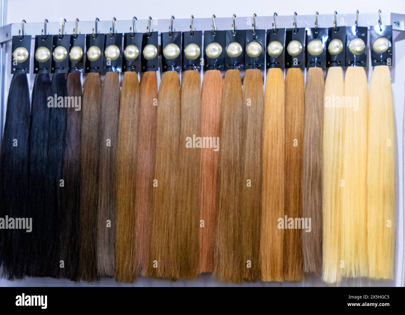 Vielfältiges Sortiment an Haarverlängerungen, Perücken und Accessoires in verschiedenen Farben und Texturen für die persönliche Pflege und das Styling in einem Schönheitssalon oder Stockfoto