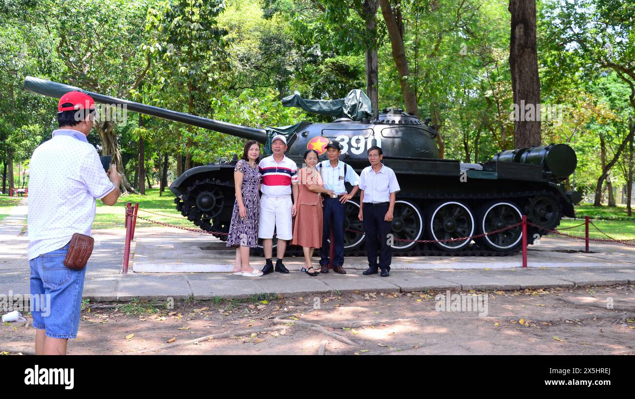 Das tägliche Leben in Ho-Chi-Minh-Stadt, die früher Saigon hieß, in Vietnam, Asien. Die Leute posieren für ein Foto mit einer Nachbildung eines der Panzer, der die Stadt 1975 befreite, als der Vietnamkrieg, von den Vietnamesen als amerikanischer Krieg bezeichnet, endete. Der Panzer befindet sich auf dem Gelände des Unabhängigkeitspalastes, auch als Wiedervereinigungspalast bezeichnet. Stockfoto