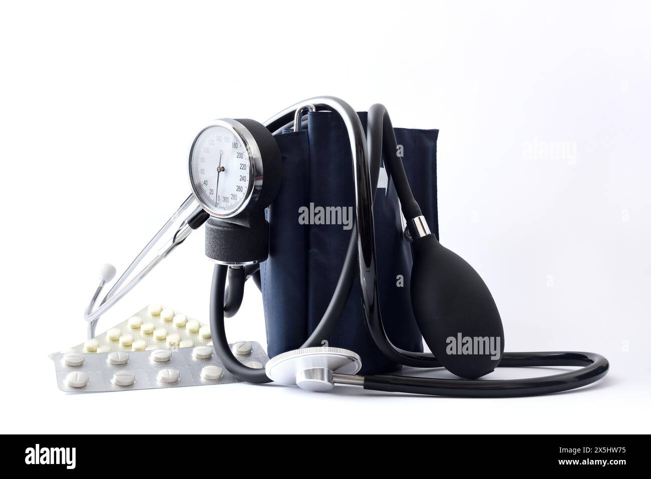 Medizinisches Kontrollkonzept mit manuellem Blutdruckmessgerät mit Stethoskop und Medikamenten auf isoliertem weißem Hintergrund. Vorderansicht. Stockfoto