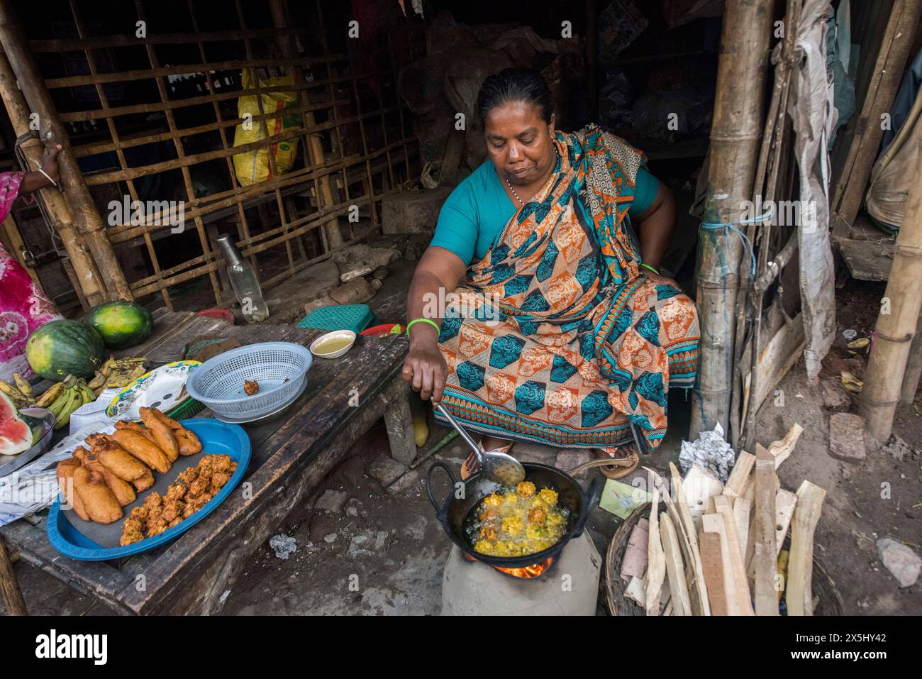 Bangladesch, Khulna, Sonadanga. Eine Frau kocht über einem Lehm-Feuer in ihrem kleinen Restaurant. (Nur für redaktionelle Zwecke) Stockfoto