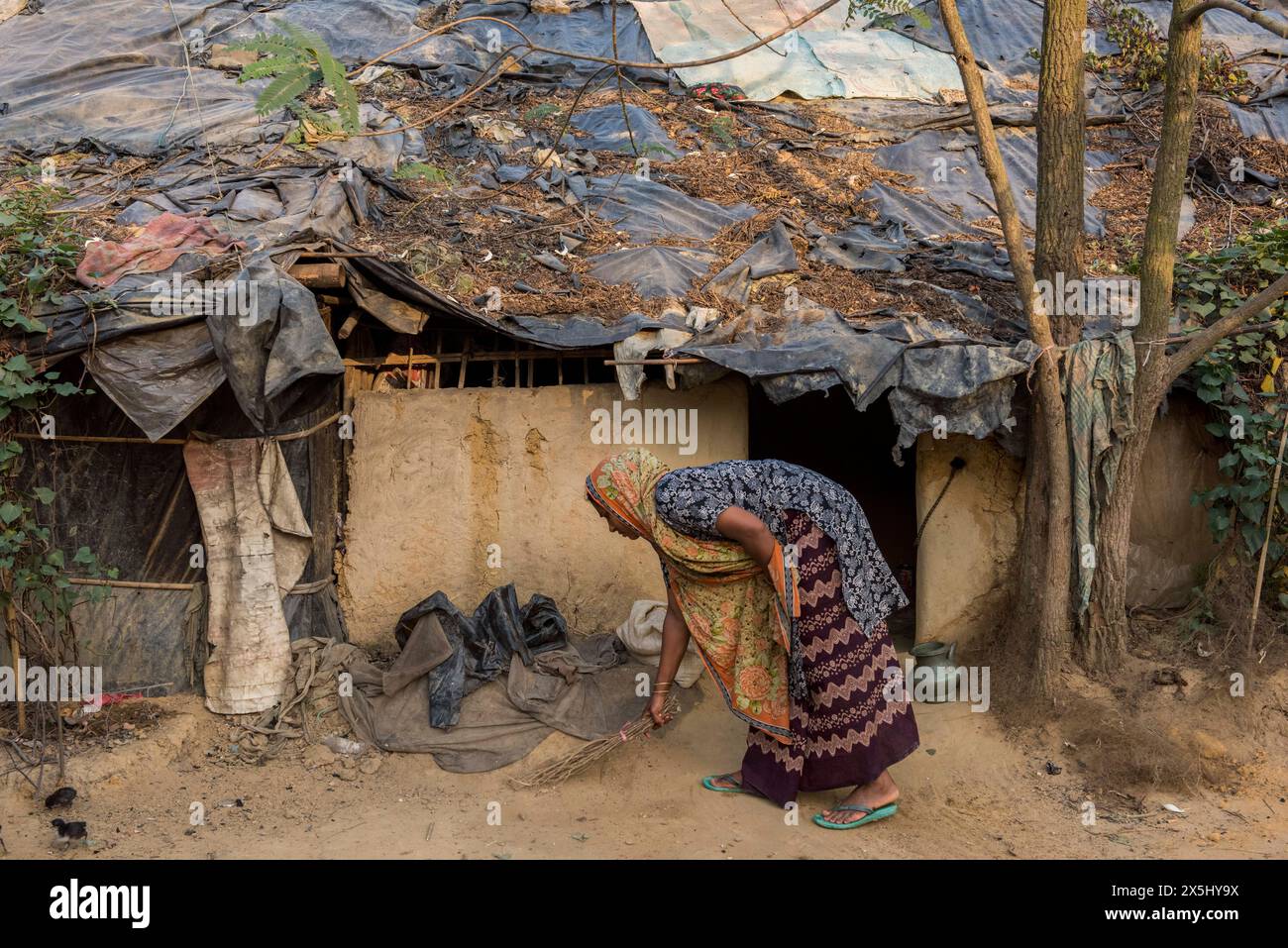 Bangladesch, Cox's Bazar. Im Kutupalong Rohingya Flüchtlingslager fegt eine Frau ihre vordere Treppe. (Nur für redaktionelle Zwecke) Stockfoto