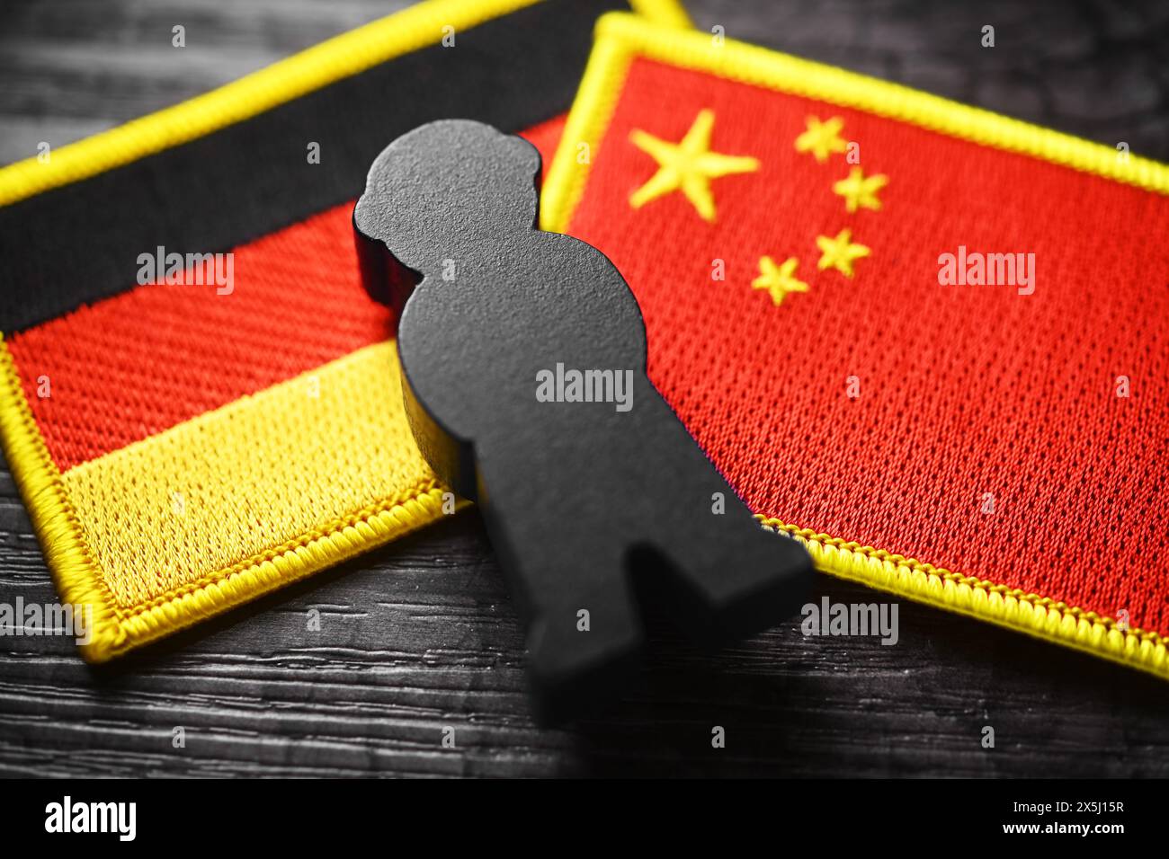 Schwarze Figur auf den Fahnen von Deutschland und China, Symbolfoto chinesische Spionage Stockfoto