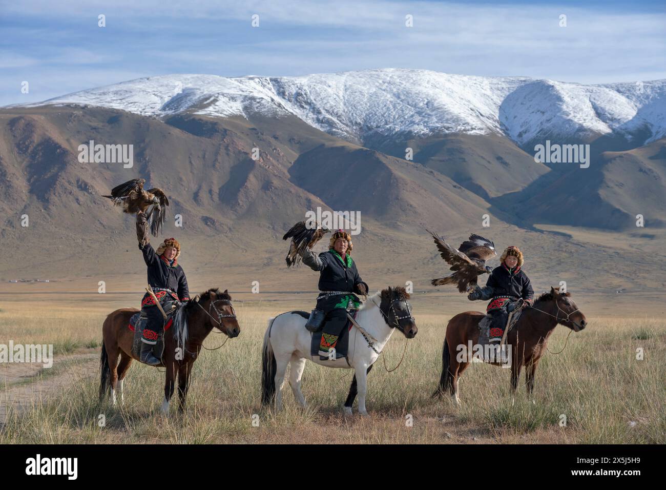 Asien, Mongolei, Provinz Bayan-Olgii. Altai Eagle Festival, drei kasachische Adlerjäger tragen ihre Adler auf dem Weg zum Festival. (Nur Für Redaktionelle Zwecke) Stockfoto