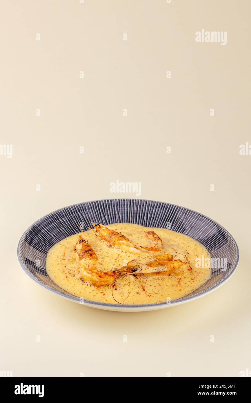 Käsesuppe mit Garnelen auf einem Teller Stockfoto