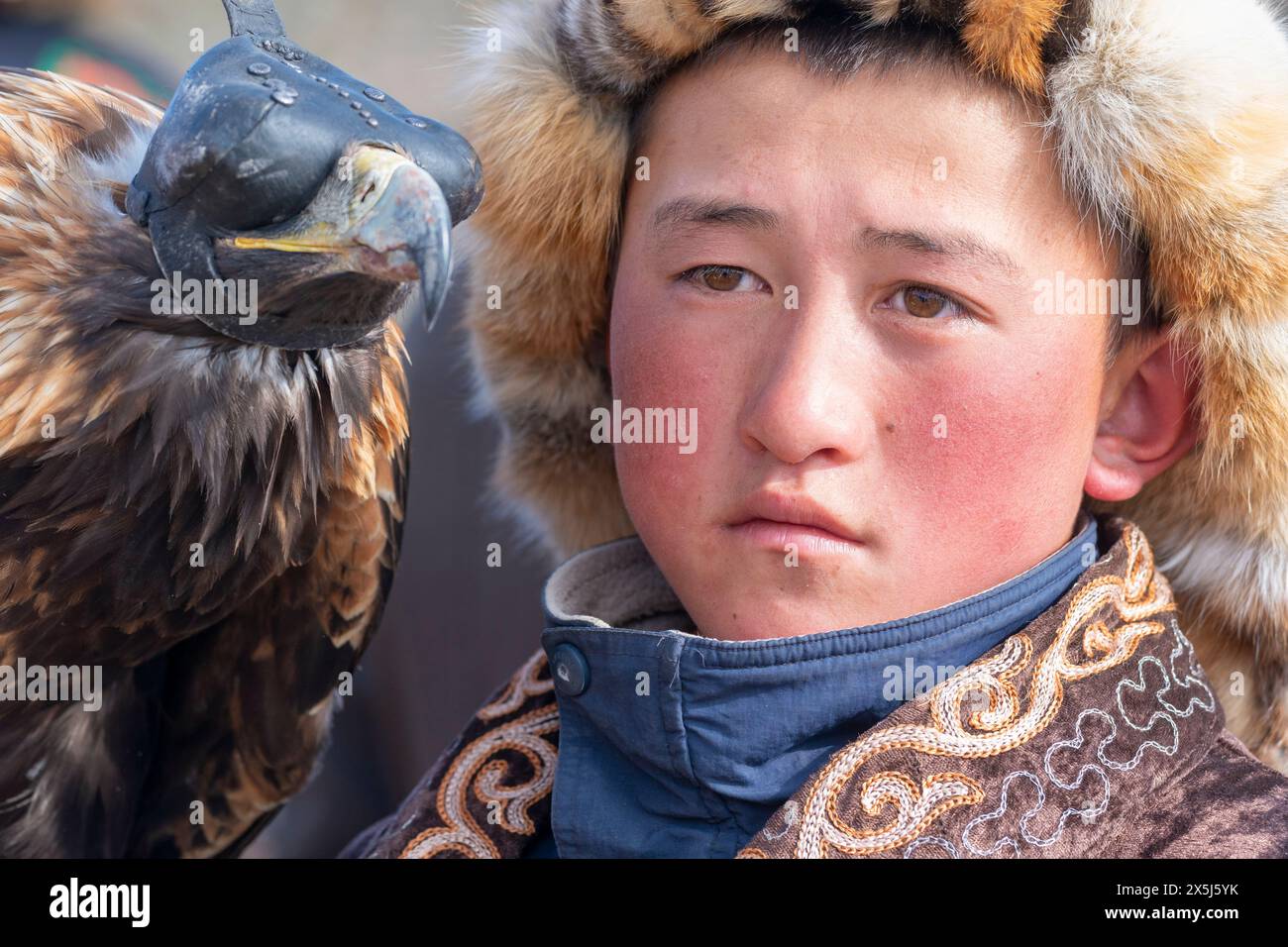 Asien, Mongolei, Provinz Bayan-Oglii. Altai Eagle Festival, Porträt eines Jungen und seines goldenen Adlers. (Nur Für Redaktionelle Zwecke) Stockfoto