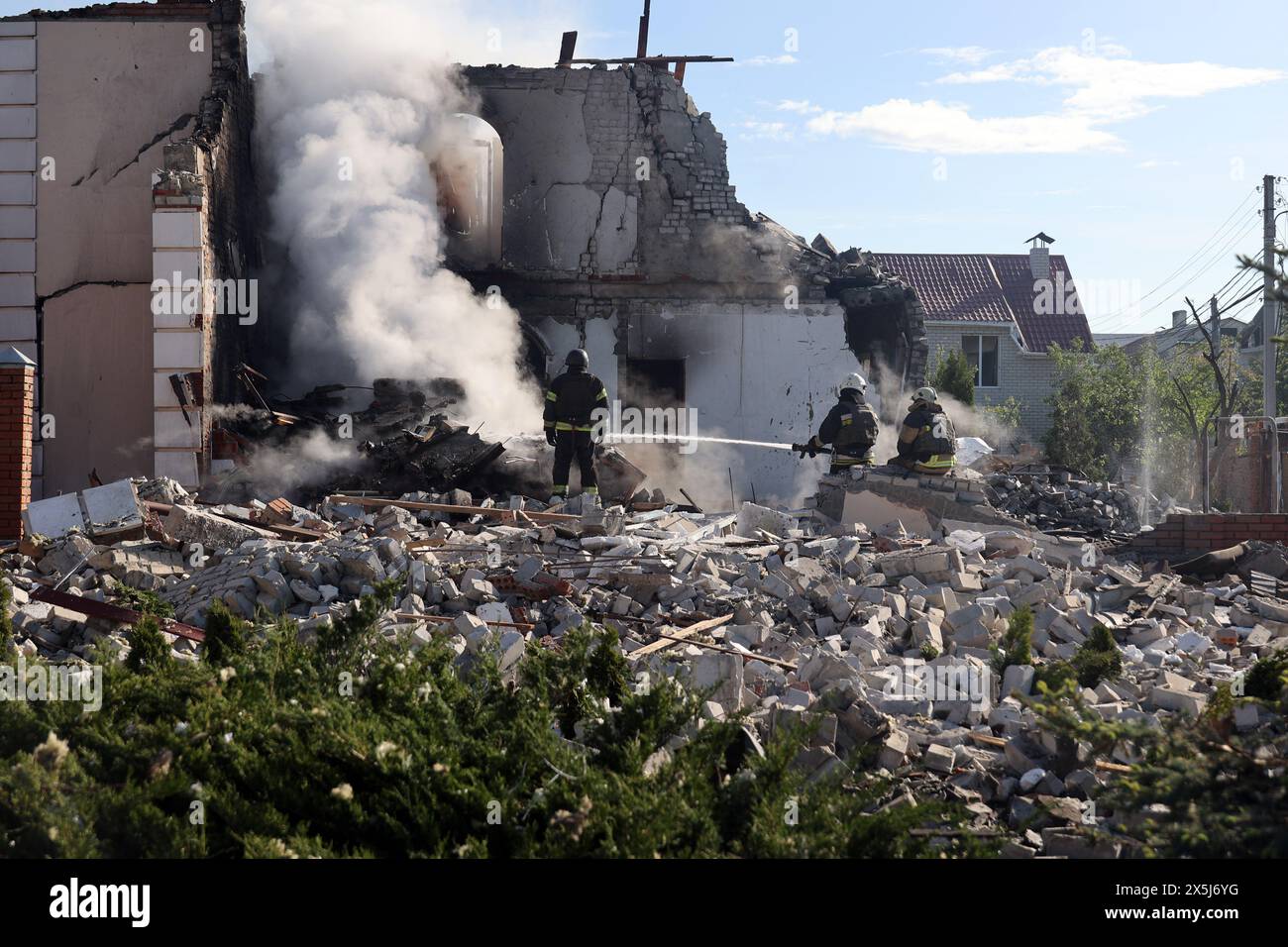 CHARKIW, UKRAINE - 10. MAI 2024 - Retter werden nach einem russischen Raketenangriff in einem Haus bei der Arbeit gesehen, Charkiw, Nordostukraine. In der Nacht des 10. Mai griffen russische Invasoren Charkiw mit einer S-300-Rakete an. Ein Kind im Alter von 11 Jahren und eine 72-jährige Frau wurden bei dem Angriff auf den privaten Sektor verletzt. Drei Häuser brannten in Brand, zwei davon wurden zerstört und eines wurde beschädigt. Insgesamt wurden 26 Gebäude zerstört und mehr als 300 Fenster zertrümmert. Stockfoto