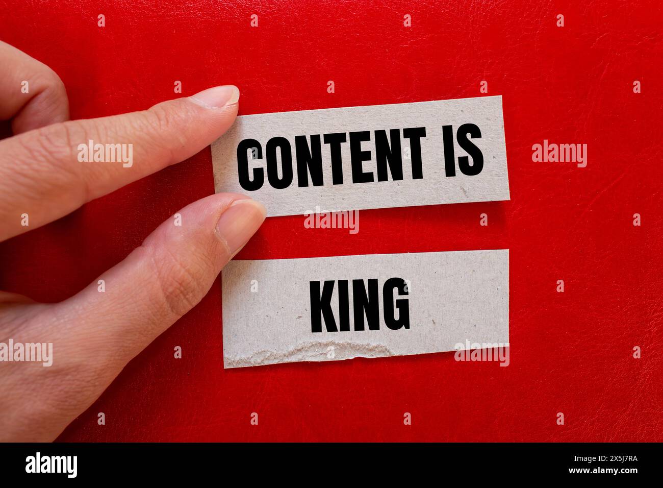 Inhalt ist Königsworte auf Papierstücken mit rotem Hintergrund. Konzeptueller Inhalt ist das Königssymbol. Kopierbereich. Stockfoto