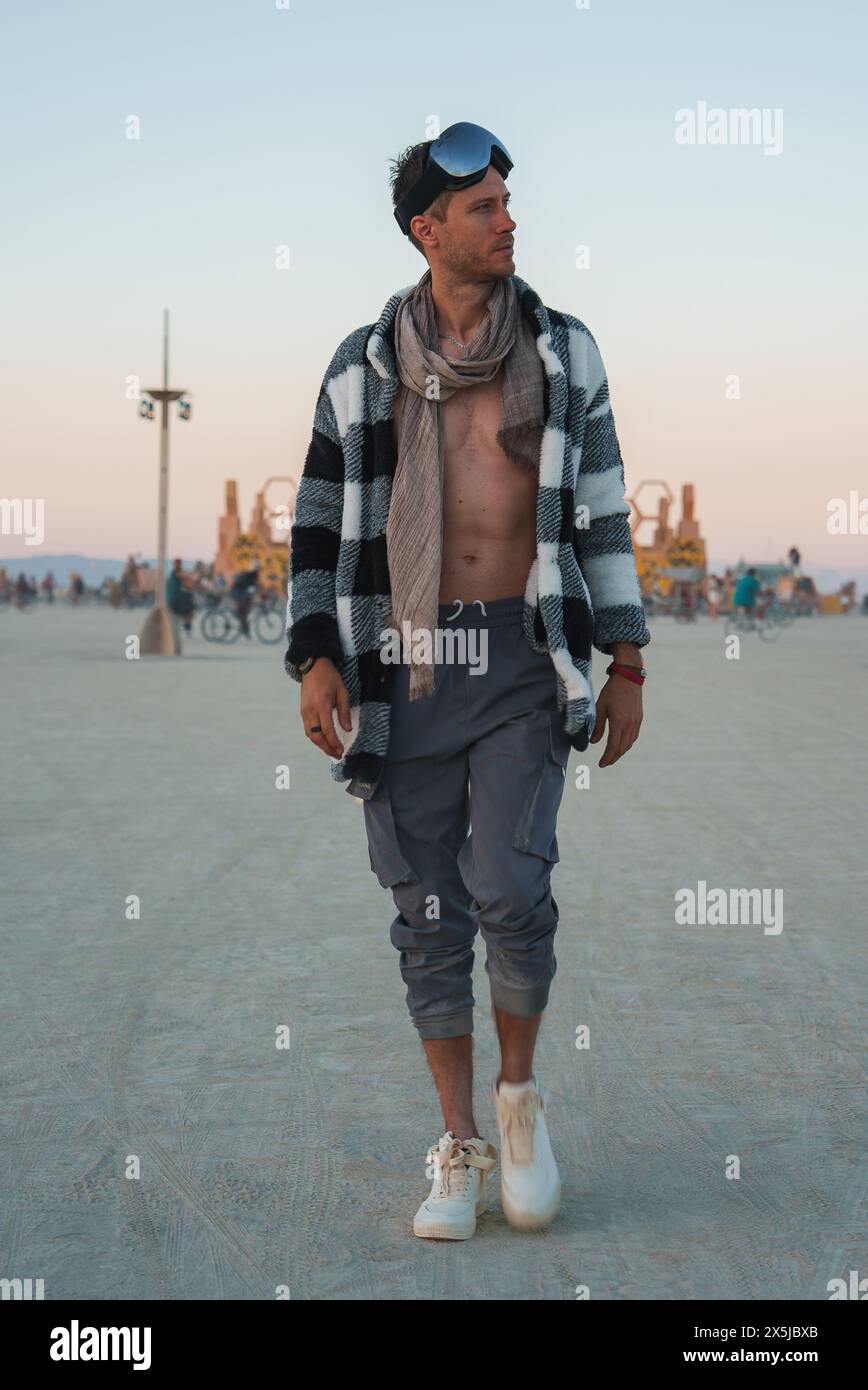 Mann in Festivalkleidung Walking Desert Festivalszene Stockfoto