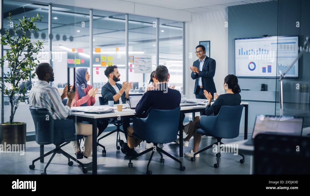 Konferenzraum Für Multi-Ethnic-Büros. Der indische CEO hält eine Präsentation für verschiedene junge Unternehmer, spricht, verwendet TV mit Infografiken, Statistiken, Diagrammen. Geschäftsleute investieren in E-Commerce Startup Stockfoto
