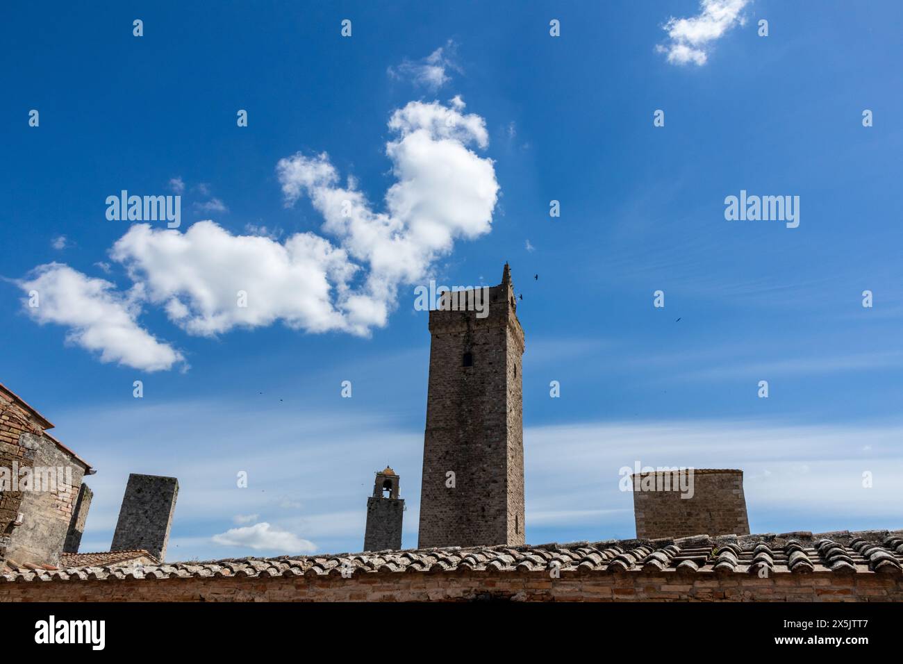 Die wunderschönen historischen Türme von San Gimignano in der Toskana, Italien an einem sonnigen Tag mit blauem Himmel. Ein Blick vom Boden bis zum Gipfel des Himmels. Stockfoto