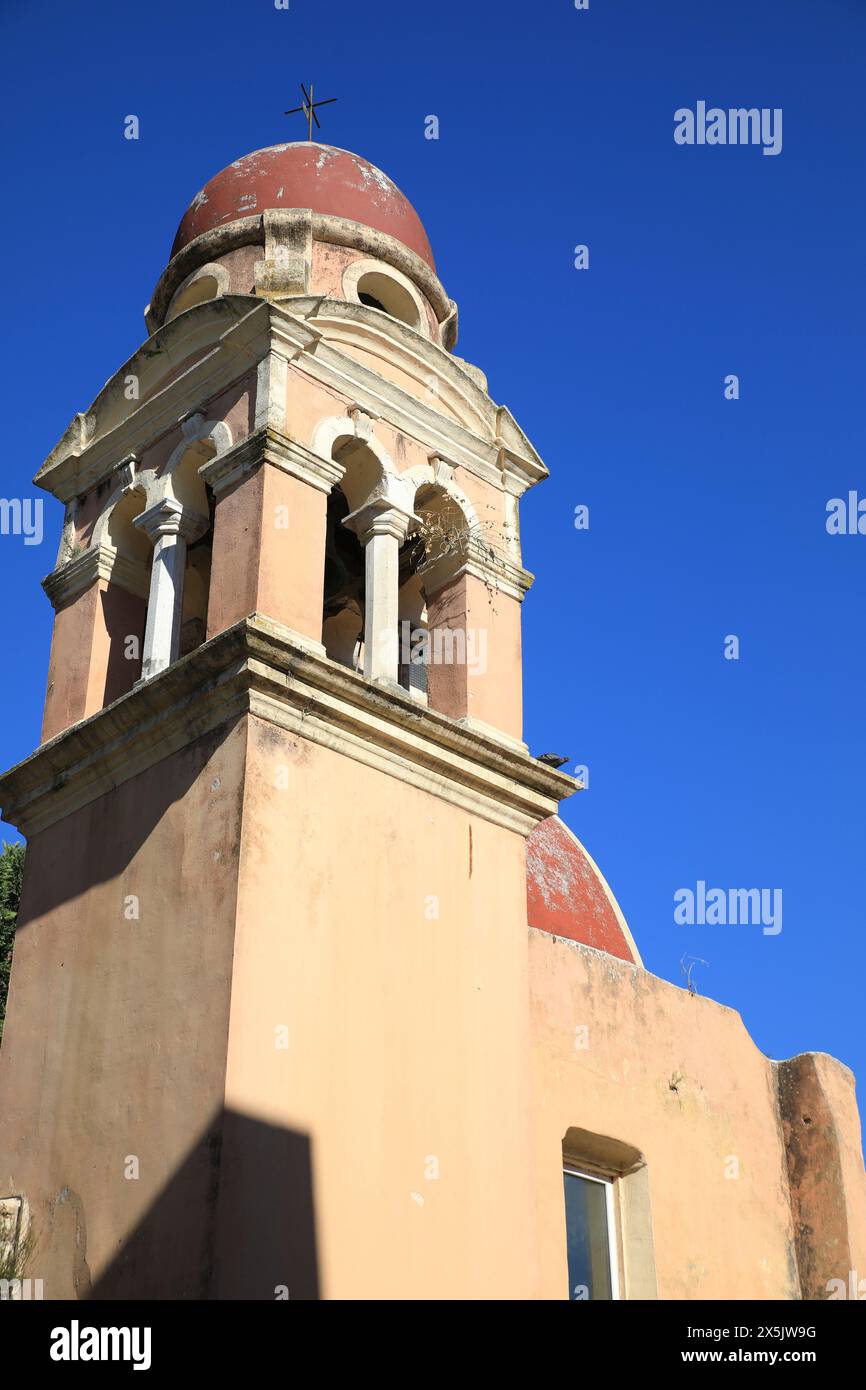 Korfu, Griechenland. Rote Kirchenkuppel, Terrakotta-Wände und Bogenfenster Stockfoto