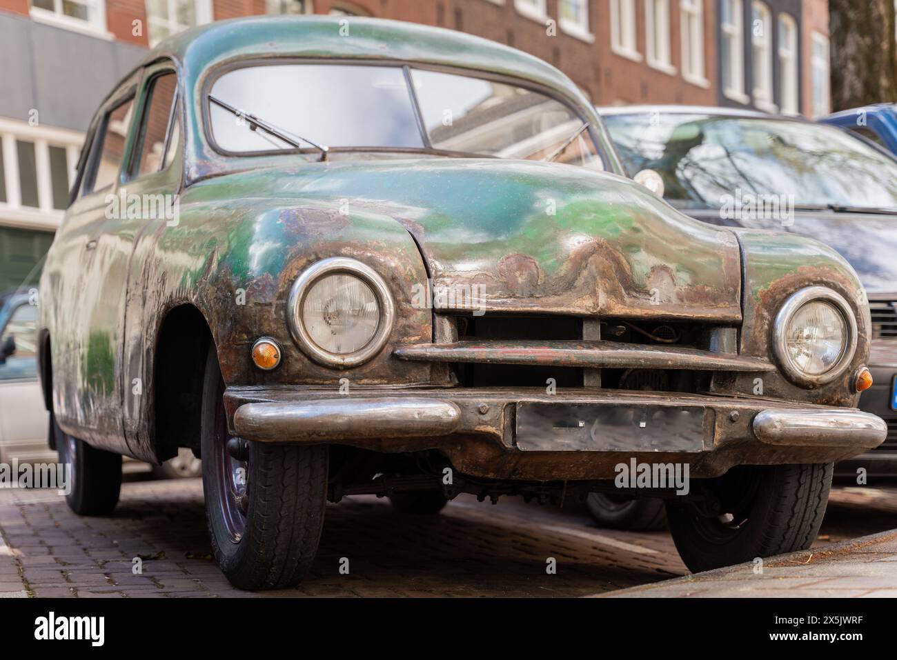 Vorderansicht des rostigen Oldtimerwagens Skoda 1200 aus dem Jahr 1953. Ein altes, verlassenes Familienauto. Stockfoto