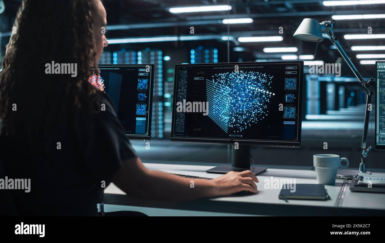 Internationale Computerwissenschaftlerin entwickelt Neural Network an ihrer Workstation. Die Anzeige zeigt die grafische Projektion des neuronalen Netzes, Simulation künstlicher Intelligenz Stockfoto