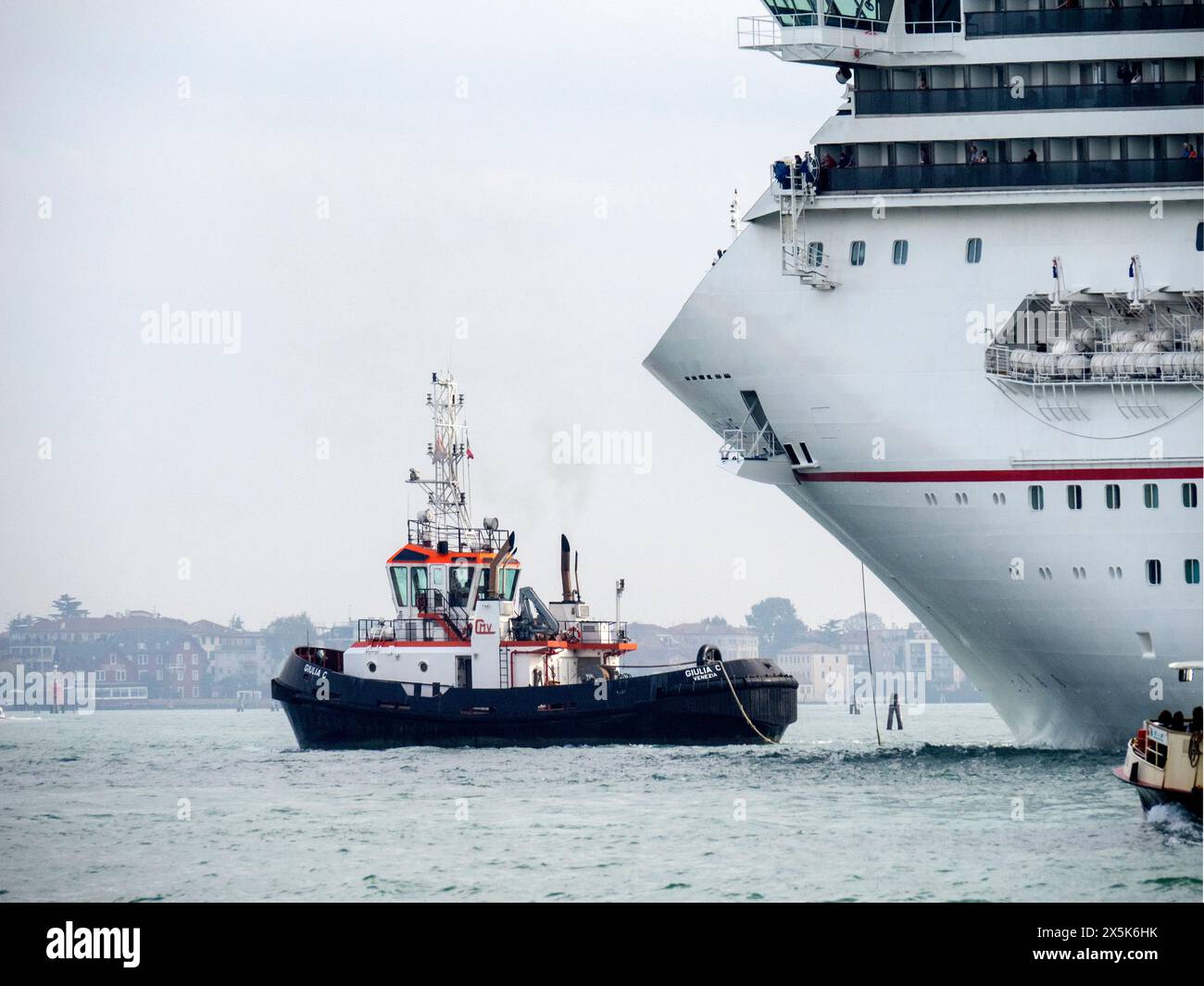 Italien, Venedig. Schlepper und Kreuzfahrtschiff. Stockfoto