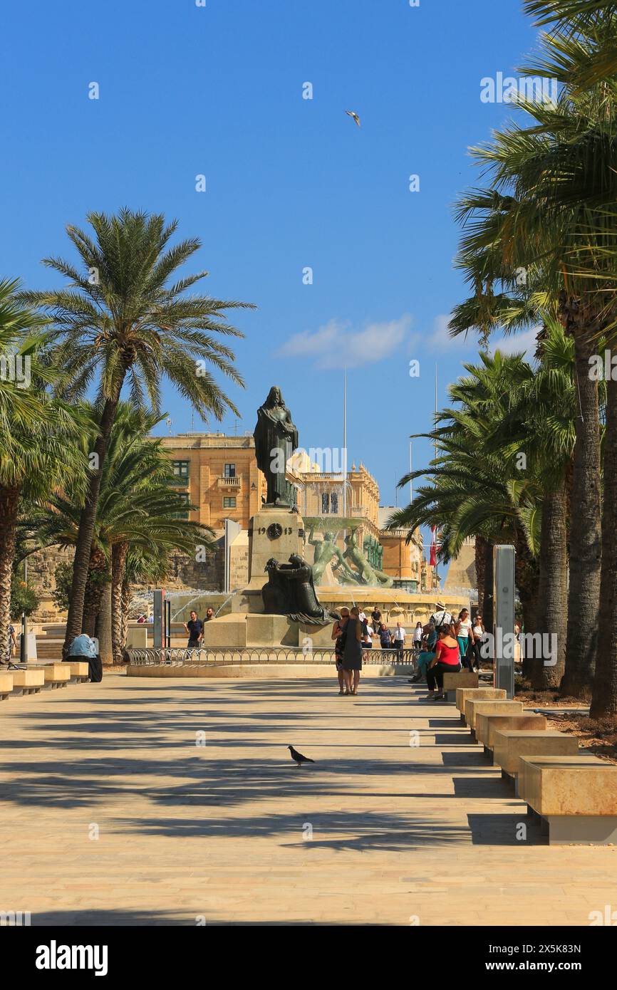 Valletta, Malta. Palmen, Parkbänke, Bronzestatuen, Tritonbrunnen und Menschen im Park Stockfoto