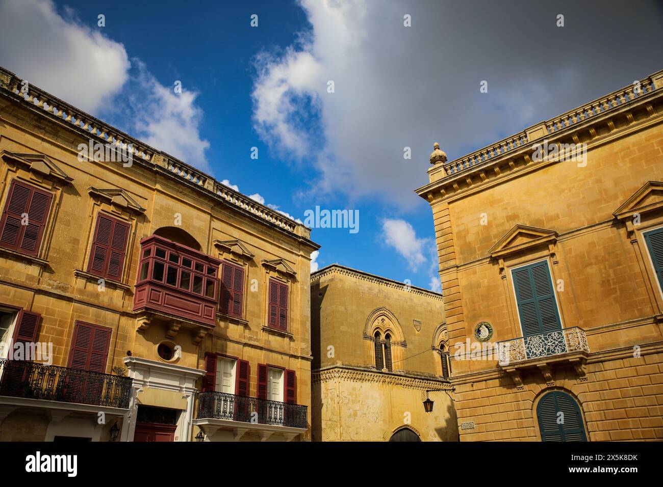 Mdina, Malta. Alte Stadt Kalkstein ockerfarbene kaiserliche Gebäude, farbige Balkone Stockfoto