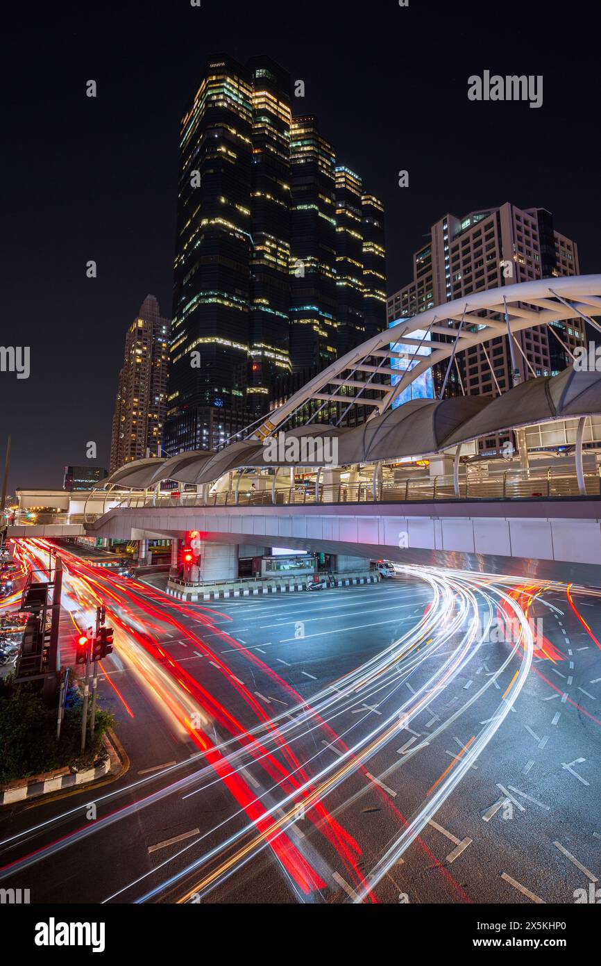 Chong Nonsi Skywalk - beleuchtete Fußgängerzone, Wolkenkratzer und Stau im zentralen Geschäftsviertel der Innenstadt in Bangkok, Thailand in der Abenddämmerung Stockfoto