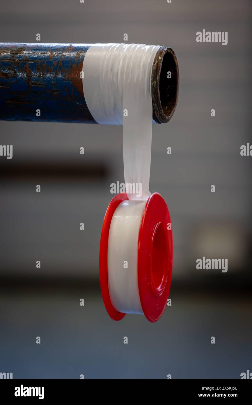 Abdichten von Gewinden mit BSP-, NPT- oder metrischem Gewinde mit Teflonband an einem Rohr oder Rohr in einer industriellen Umgebung, Niederlande Stockfoto