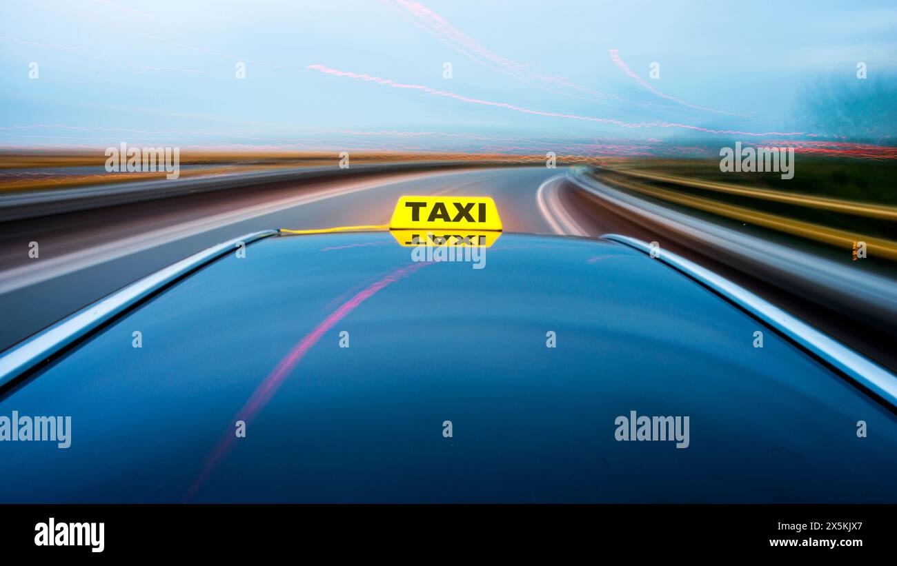 Taxi fährt entlang einer Straße und nähert sich einer Kurve auf einer Autobahnausfahrt. Stockfoto
