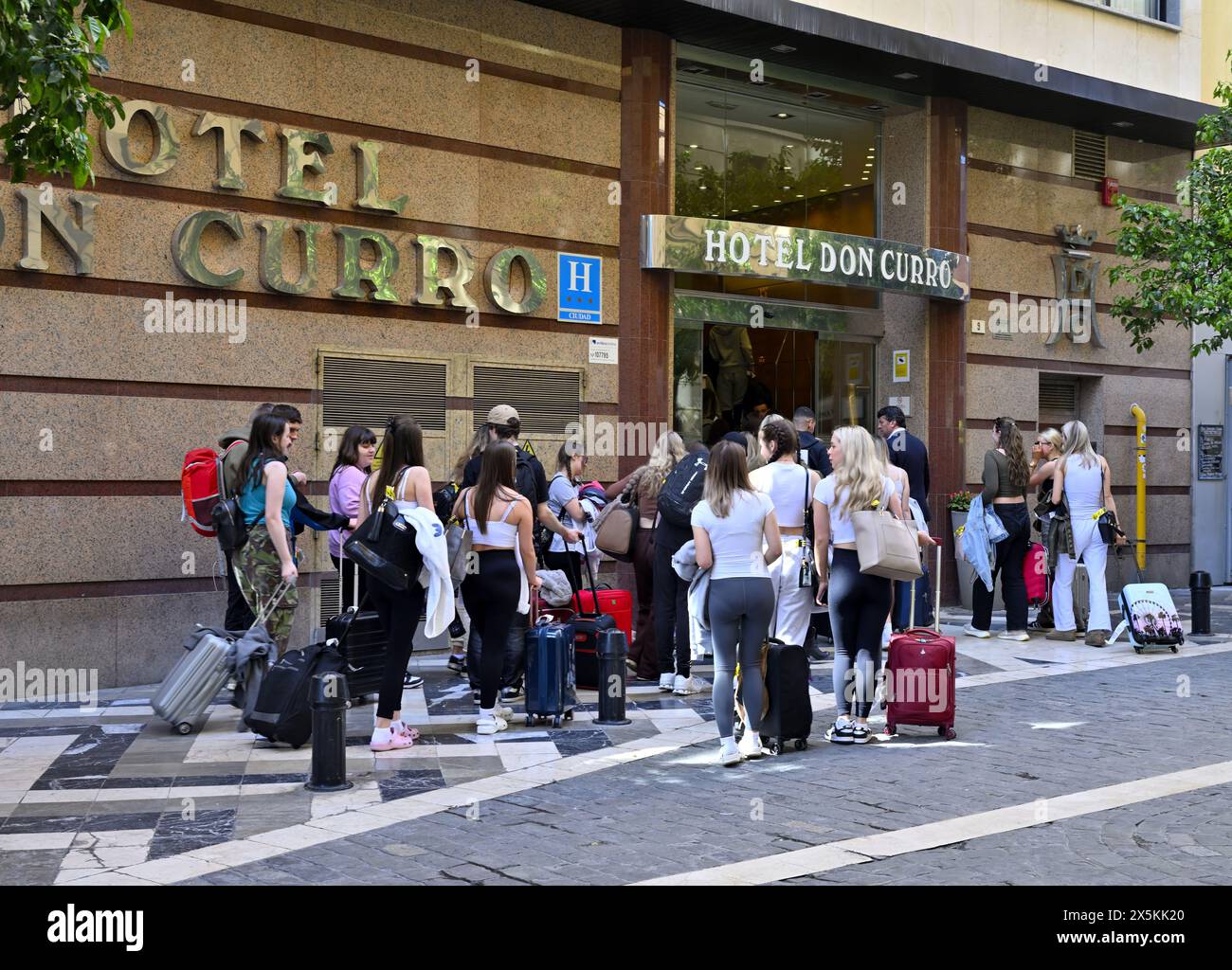 Touristen in Gruppe mit Koffern in der Schlange, um im Hotel Don Curro im Zentrum von Malaga, Spanien, einzuchecken Stockfoto