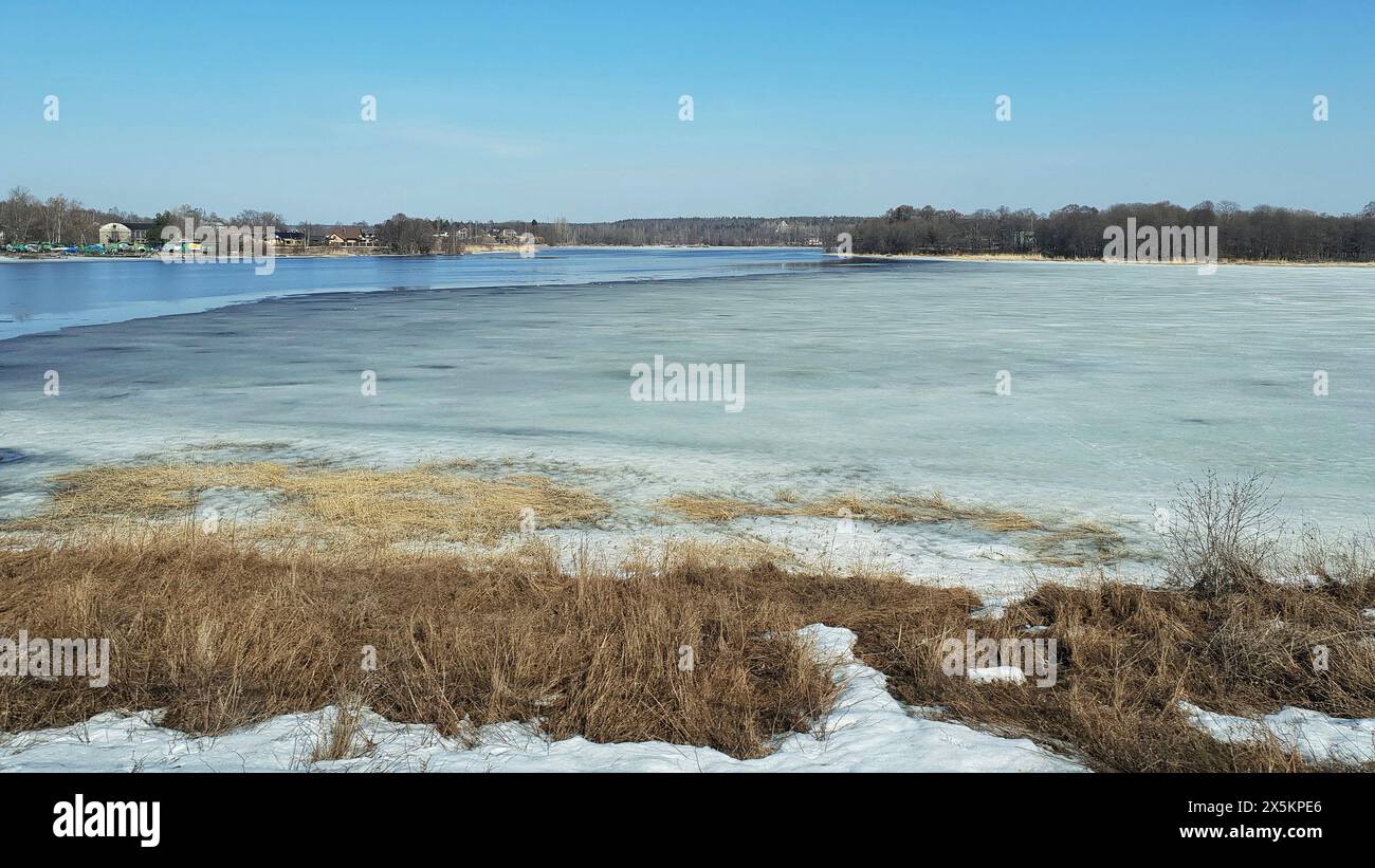 Der Blick über einen Fluss im Winter, mit Eis an der Oberfläche. Stockfoto