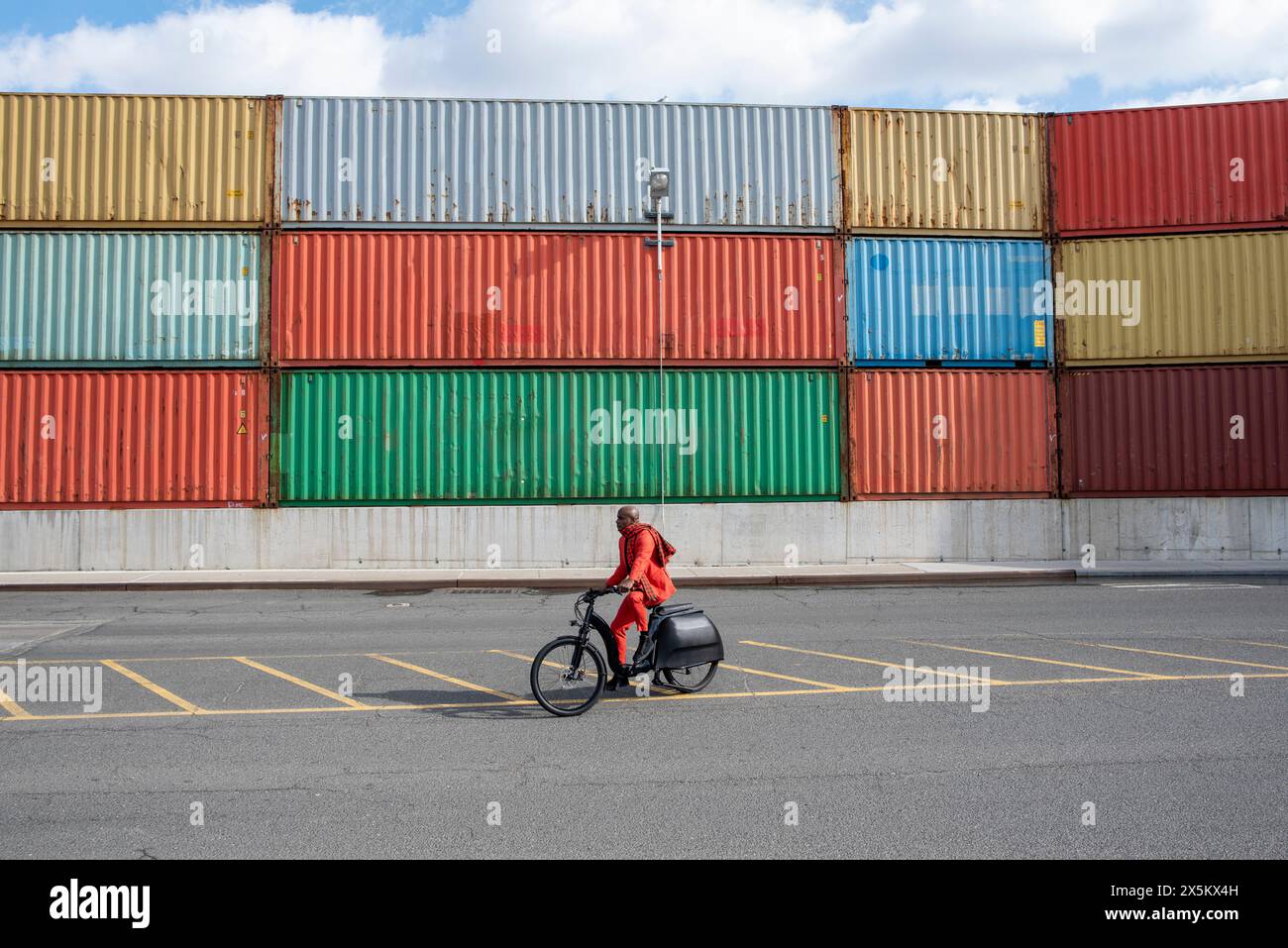 USA, Bundesstaat New York, New York City, Mann im roten Anzug, der Fahrrad in Brooklyn fährt Stockfoto