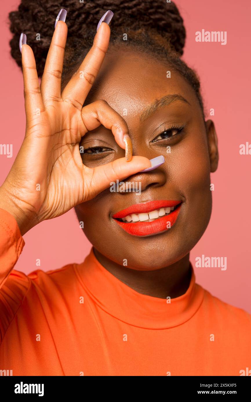 Studio-Porträt einer stilvollen Frau, die ein OK-Zeichen macht Stockfoto