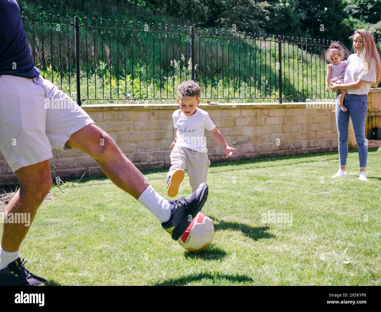 Vater mit Sohn spielt Fußball im Hinterhof Stockfoto
