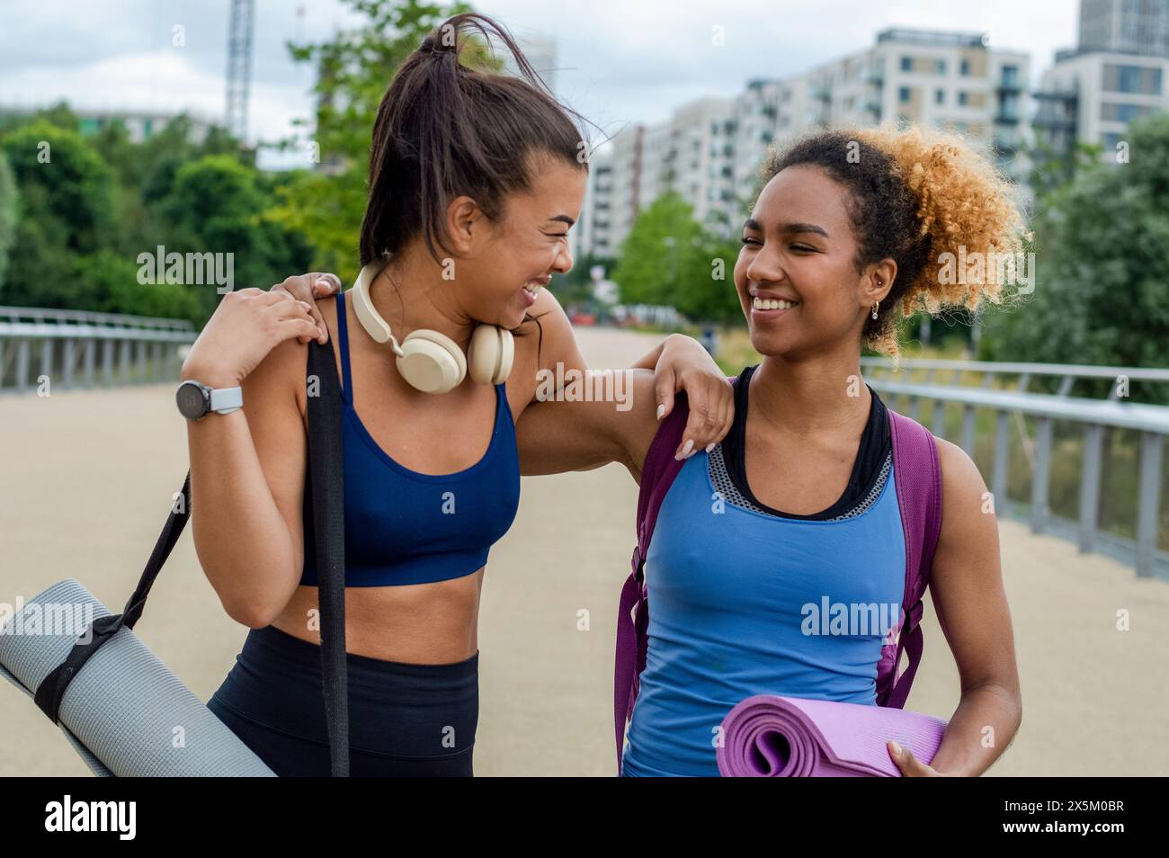 Lachende Freundinnen, die Yoga praktizieren Stockfoto