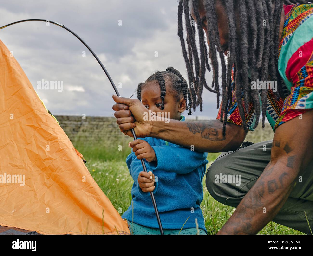 Vater und Tochter bauen ein Zelt auf Stockfoto