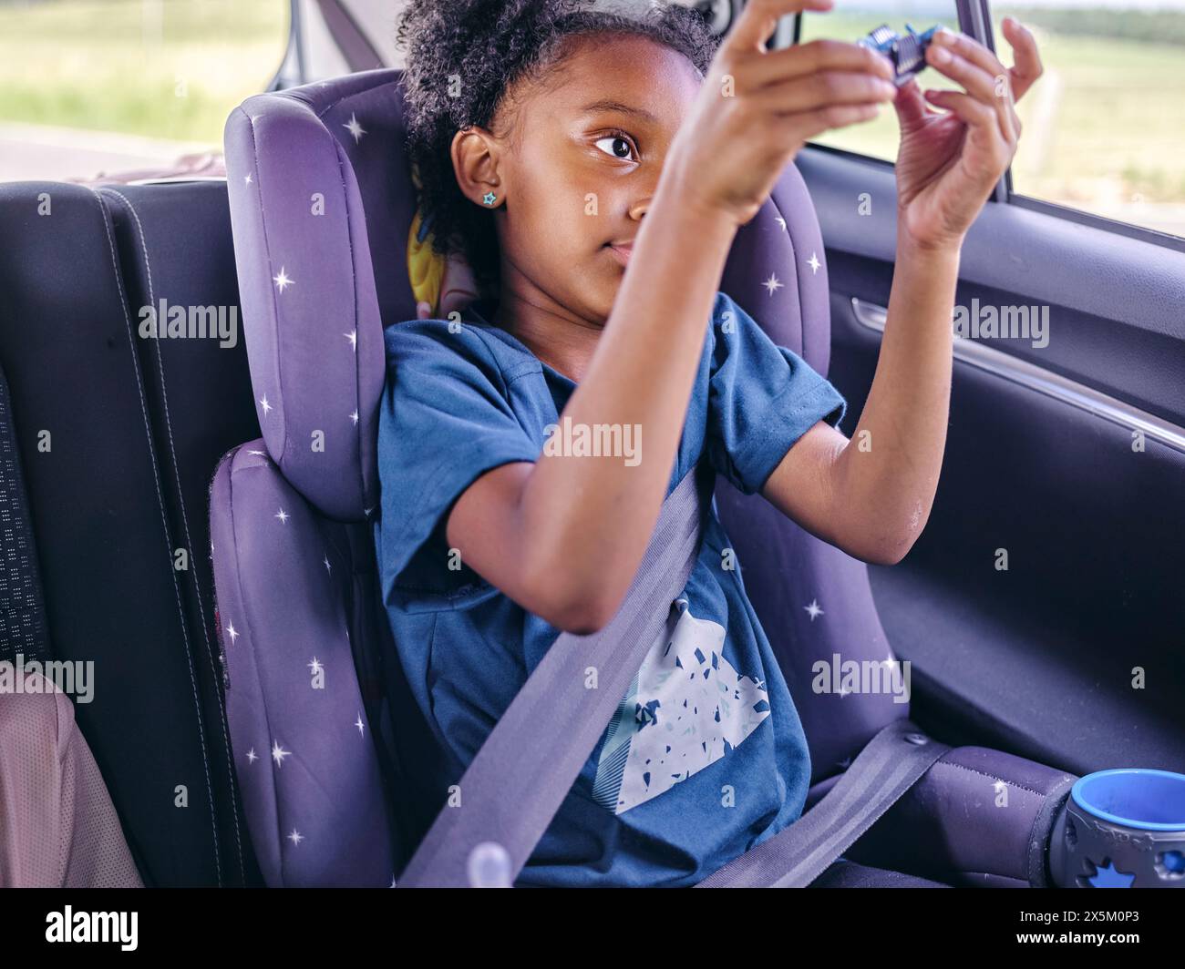 Mädchen, das auf einem Autositz sitzt Stockfoto