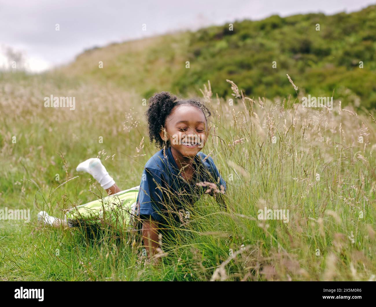 Lächelndes Mädchen im Grass liegen Stockfoto