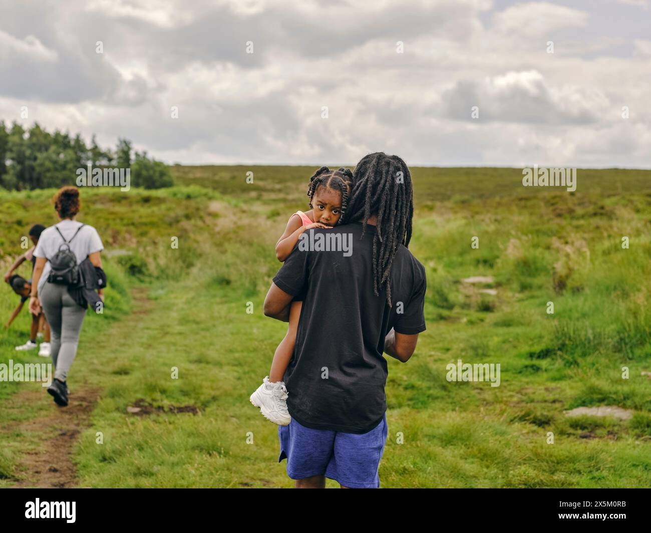 Vater trägt Tochter auf Spaziergang in der Natur Stockfoto