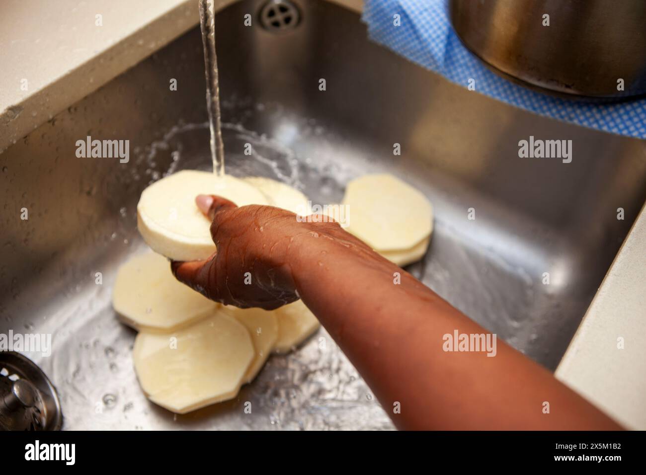 Frau wäscht Yamsscheiben Stockfoto