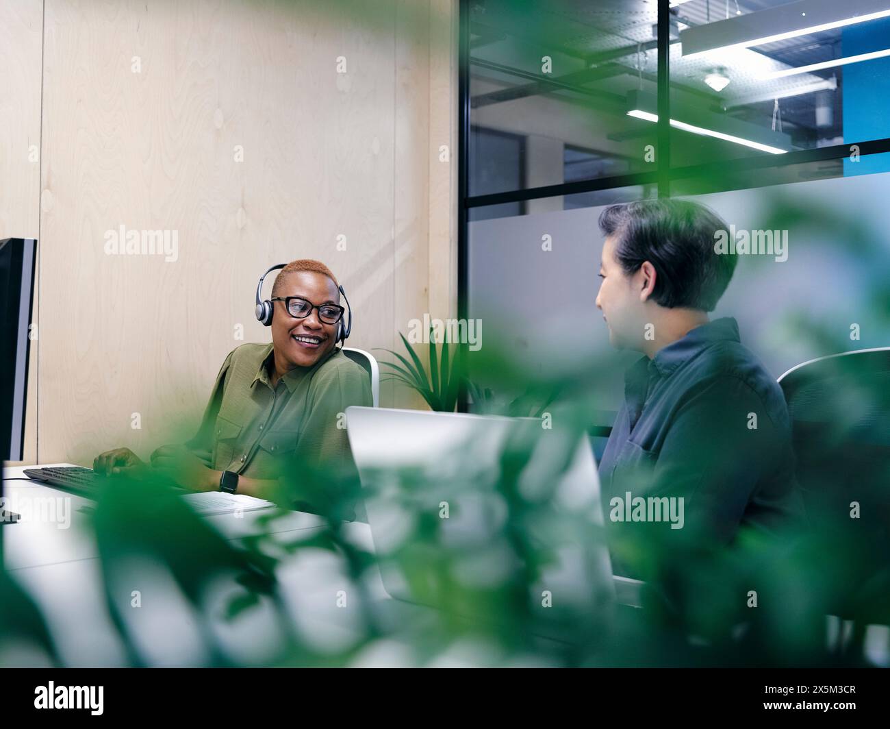 Büromitarbeiter, die Computer in kooperierenden Bürobereichen verwenden Stockfoto