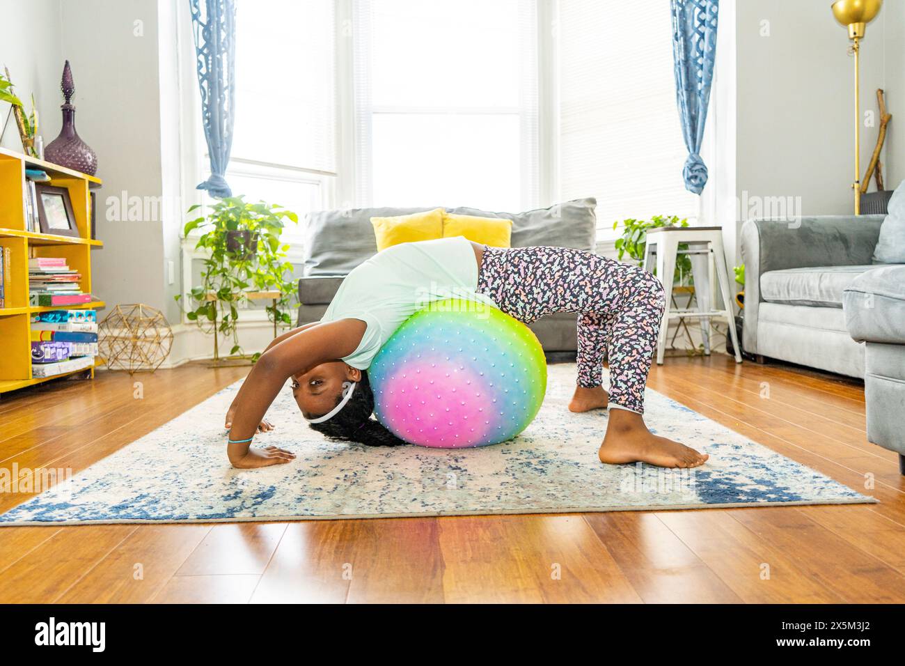 Mädchen, das mit Fitnessball in ihrem Zimmer trainiert Stockfoto