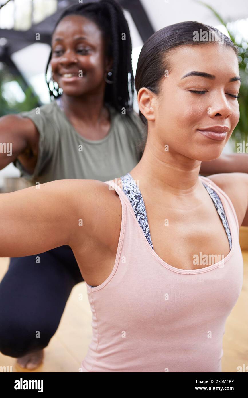 Weibliche Ausbilderin, die einer Frau beim Pilates im Studio hilft Stockfoto