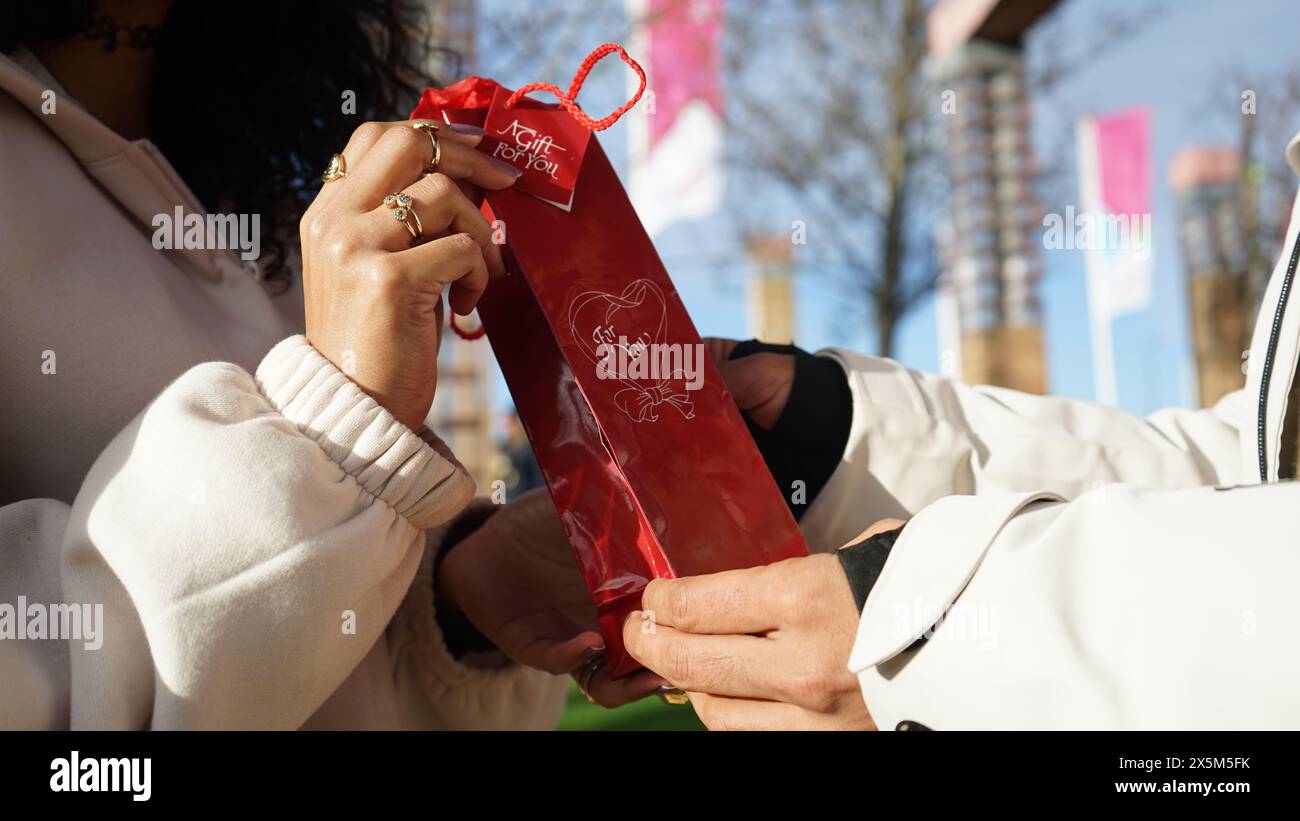Nahaufnahme der Hände eines Paares mit Geschenk Stockfoto