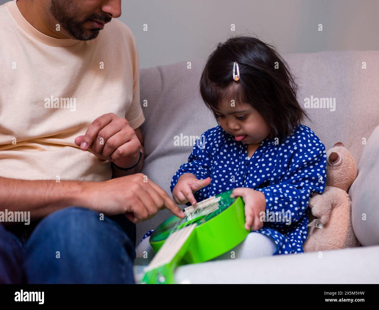 Vater spielt mit Spielzeuggitarre mit Tochter Stockfoto