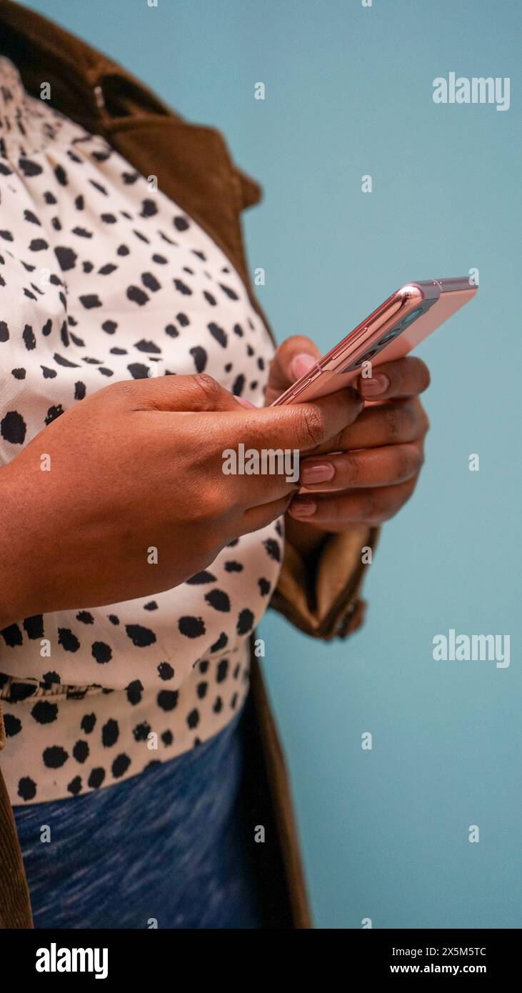 Der mittlere Teil der Frau, die das Telefon benutzt Stockfoto