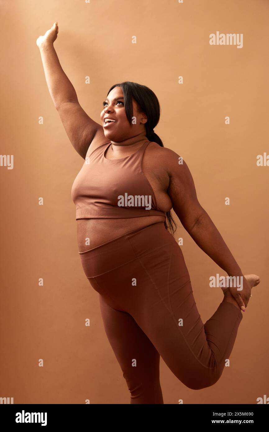 Studio-Aufnahme von lächelnder und großer Frau, die Sport treibt Stockfoto