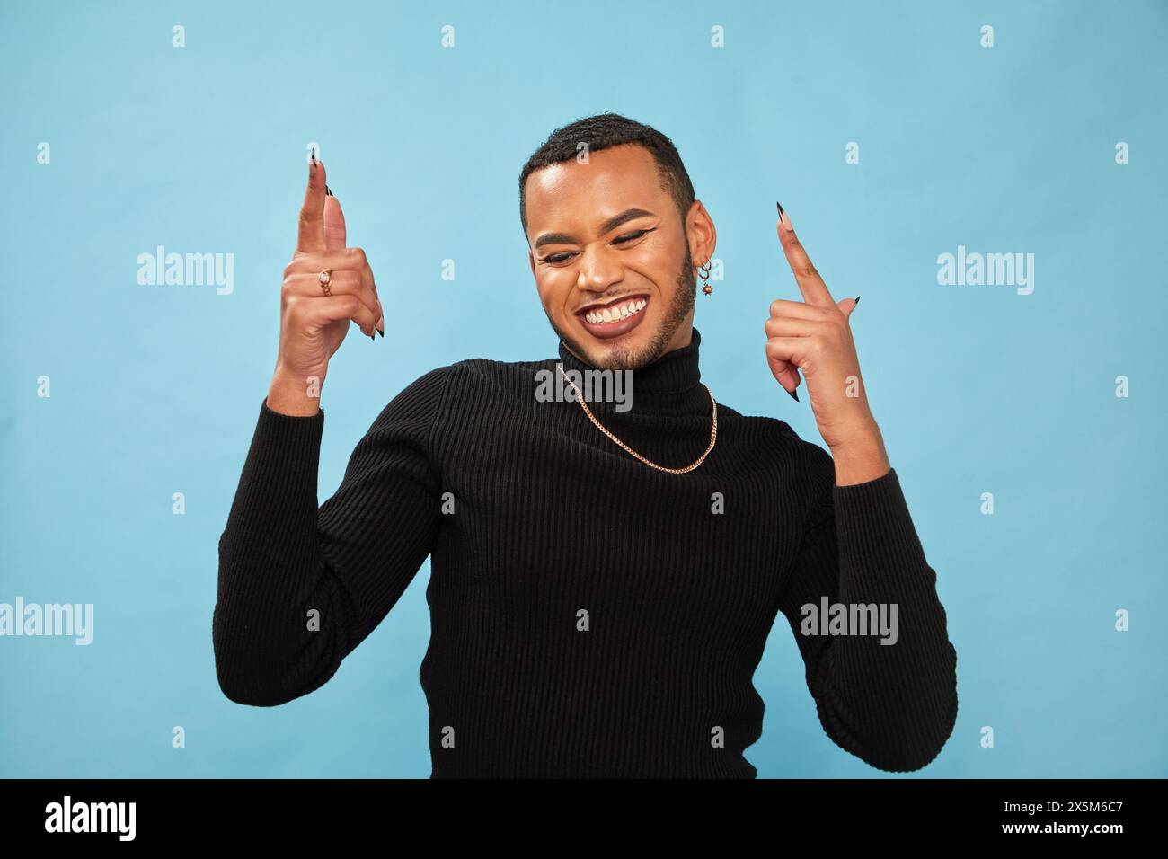 Studio-Porträt eines lächelnden queeren Mannes Stockfoto
