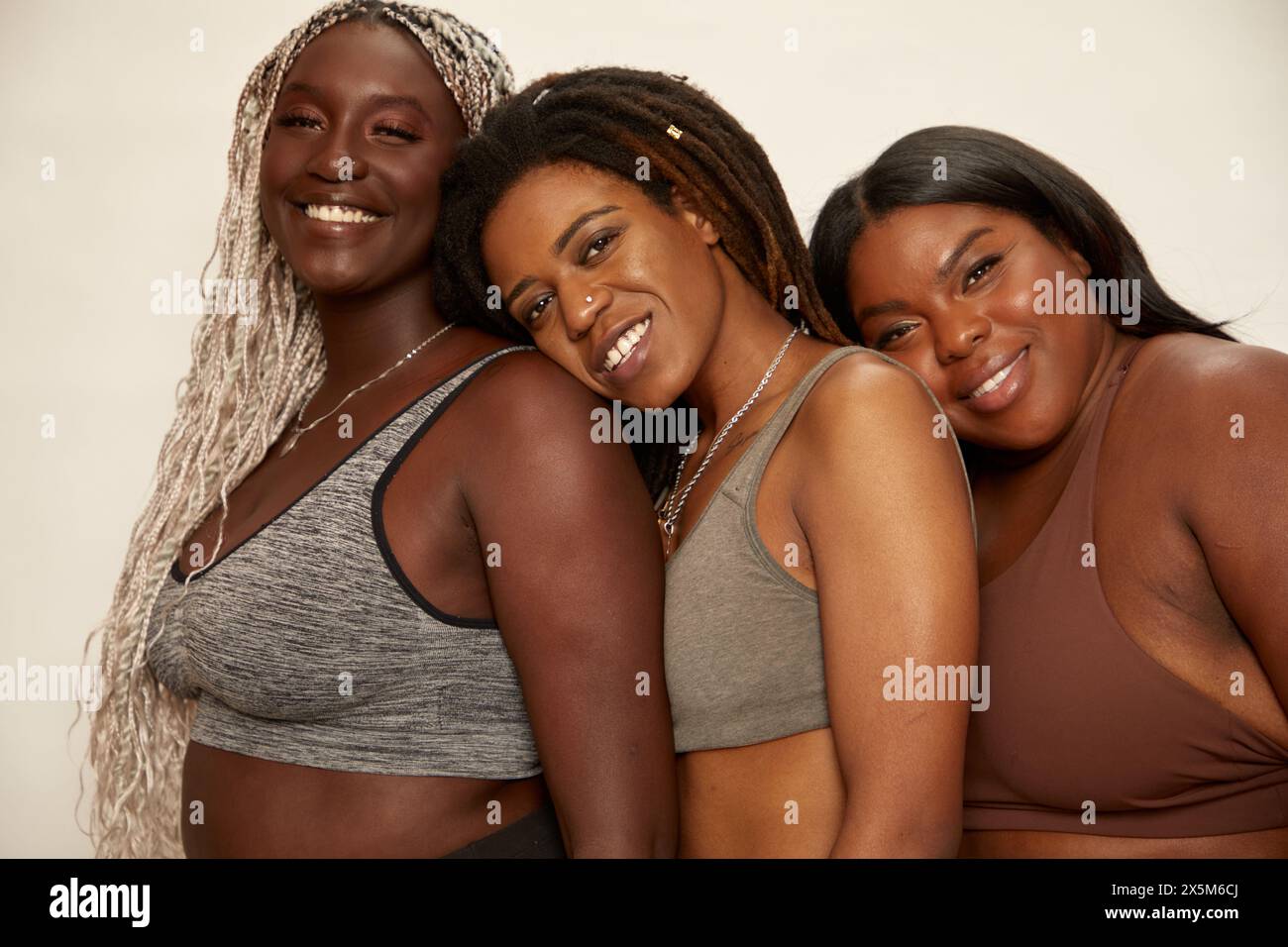 Studio-Porträt von drei lächelnden Frauen in Sportbekleidung Stockfoto