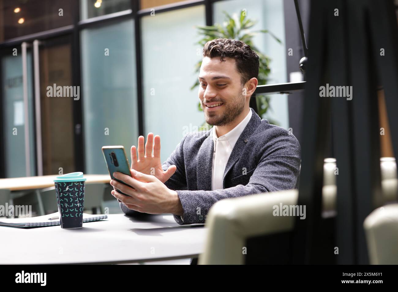 Lächelnder Geschäftsmann, der Videoanruf am Telefon hat Stockfoto