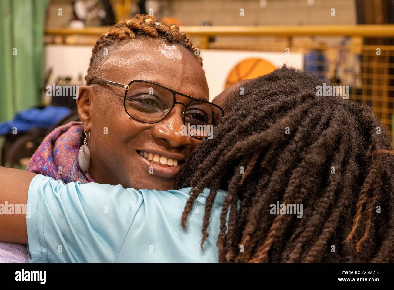 Teenager-Mädchen umarmt Großmutter Stockfoto