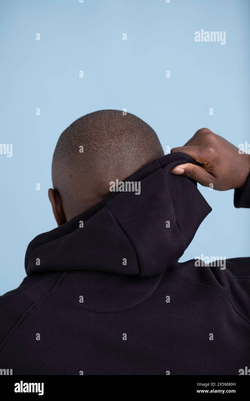 Rückansicht eines Mannes im mittleren Erwachsenenalter mit schwarzem Hoodie Stockfoto