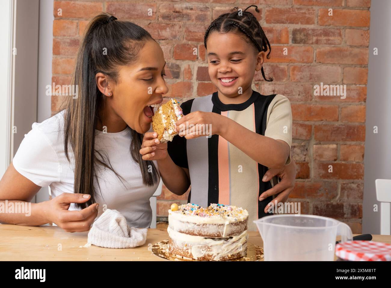 Mutter und Sohn essen Kuchen in der Küche Stockfoto